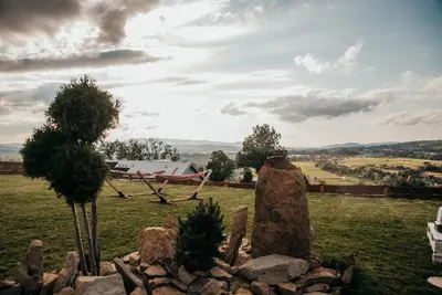 a garden with a bench and a tree in a field at Górskie Tarasy in Rabka