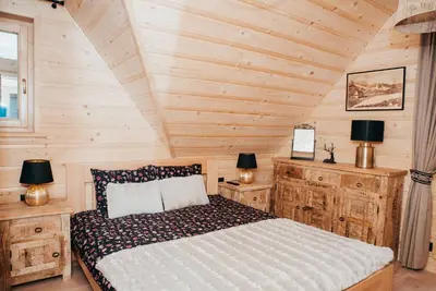 a bedroom with a bed in a wooden cabin at Górskie Tarasy in Rabka