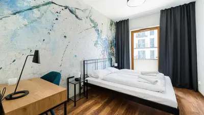 a bedroom with a bed and a desk and a wall at Novum City Center, Sun & Snow in Kraków