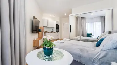 a bedroom with a bed and a table with flowers on it at Novum City Center, Sun & Snow in Kraków