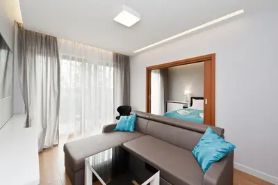 a living room with a couch and a mirror at Novum City Center, Sun & Snow in Kraków