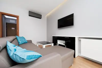 a living room with a couch and a flat screen tv at Novum City Center, Sun & Snow in Kraków