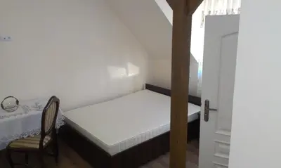 a small bedroom with a bed and a chair at Pokoje Gościnne w Ratuszu in Ogrodzieniec