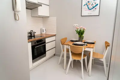 a small kitchen with a small table and chairs at Asnyka Old Town in Kraków