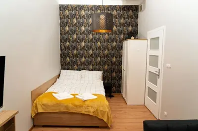 a bedroom with a bed with two towels on it at Asnyka Old Town in Kraków