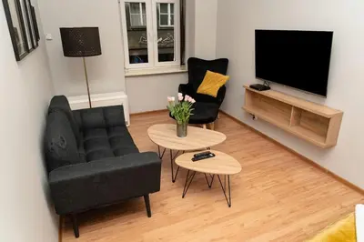 a living room with a couch and two chairs and a television at Asnyka Old Town in Kraków