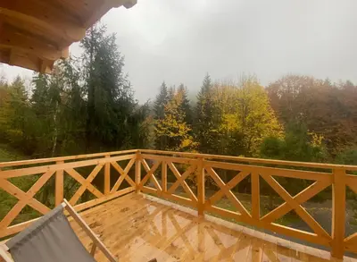 a wooden deck with a chair on a porch at Babiogórskie klimaty in Zawoja