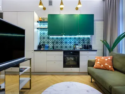 a living room with a couch and a kitchen at GREEN CHILL Apt Old Town & Wawel Hill by Vistula River - by Homelike Krakow in Kraków