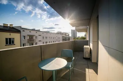 a balcony with a table and chairs on a building at Kazimierza Wielkiego Luxury Apartment by BookingHost in Kraków
