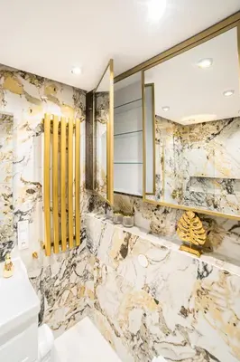 a bathroom with marble walls and a sink and a mirror at Kazimierza Wielkiego Luxury Apartment by BookingHost in Kraków