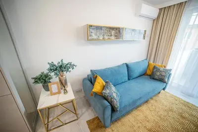 a blue couch in a living room with a table at Kazimierza Wielkiego Luxury Apartment by BookingHost in Kraków