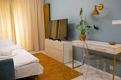 a bedroom with a bed and a desk with a television at Kazimierza Wielkiego Luxury Apartment by BookingHost in Kraków