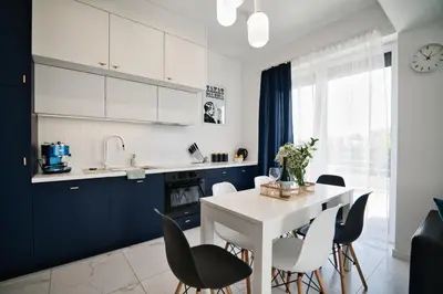 a kitchen with blue cabinets and a white table and chairs at Pankrac 2 by Housine in Zator