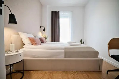a white bedroom with a large bed and a desk at Pankrac 2 by Housine in Zator