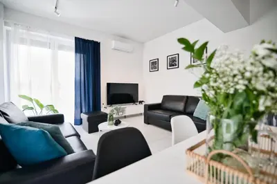 a living room with black couches and a tv at Pankrac 2 by Housine in Zator