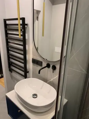 a bathroom with a white sink and a shower at Indygo Apartment in Kraków