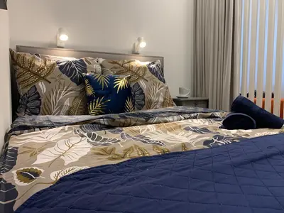 a bed with a blue comforter and pillows on it at Indygo Apartment in Kraków