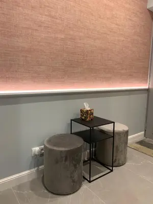 a room with a table and a stool and a wall at Indygo Apartment in Kraków