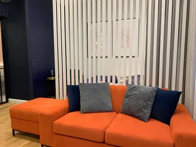 an orange couch with two pillows on it in a room at Indygo Apartment in Kraków