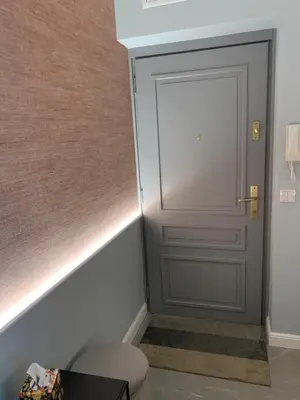 a bathroom with a door and a stool in a room at Indygo Apartment in Kraków