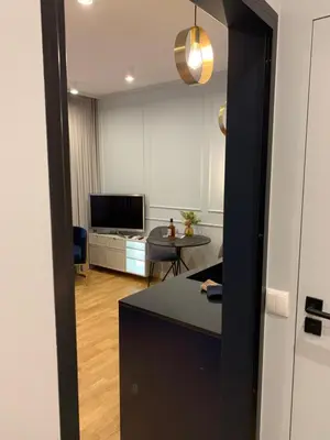 a room with a kitchen and a living room with a table at Indygo Apartment in Kraków