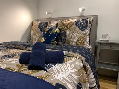 a bed with blue and white blankets and pillows at Indygo Apartment in Kraków