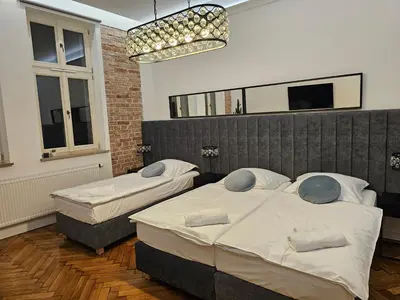a bedroom with two beds and a chandelier at JUWEL Apartments Kraków z widokiem na Wawel ap 31 in Kraków