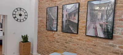 a brick wall with four framed pictures on it at JUWEL Apartments Kraków z widokiem na Wawel ap 31 in Kraków