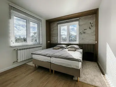 a bedroom with a bed in a room with windows at Penthouse Słoneczna Rapsodia - blisko Parku Zdrojowego - duży taras na dachu - piękny widok - winda - garaż in Rabka