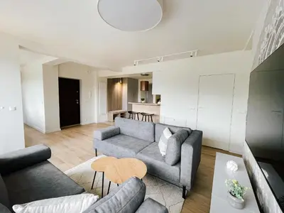a living room with a couch and a table at Penthouse Słoneczna Rapsodia - blisko Parku Zdrojowego - duży taras na dachu - piękny widok - winda - garaż in Rabka