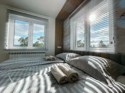 two beds in a bedroom with two pillows and windows at Penthouse Słoneczna Rapsodia - blisko Parku Zdrojowego - duży taras na dachu - piękny widok - winda - garaż in Rabka