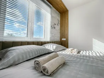a bedroom with a bed with towels on it at Penthouse Słoneczna Rapsodia - blisko Parku Zdrojowego - duży taras na dachu - piękny widok - winda - garaż in Rabka