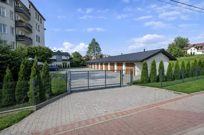 a gate in a driveway in front of a building at Penthouse Słoneczna Rapsodia - blisko Parku Zdrojowego - duży taras na dachu - piękny widok - winda - garaż in Rabka
