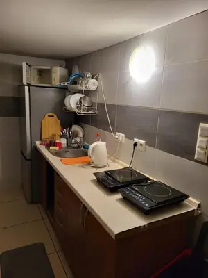 a kitchen with a counter with a sink and a refrigerator at Grzegorzecka Room nr 5 in Kraków