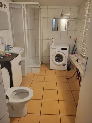 a bathroom with a toilet and a washing machine at Grzegorzecka Room nr 5 in Kraków