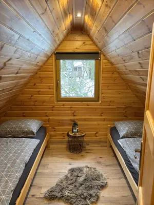 a room with two beds in a wooden cabin at Domki na granicy - Kocoń in Jeżowski Dział