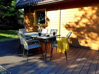 a wooden deck with a table and chairs on it at Domki na granicy - Kocoń in Jeżowski Dział