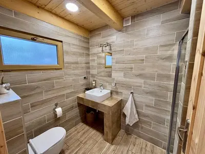 a bathroom with a sink and a toilet at Domki na granicy - Kocoń in Jeżowski Dział