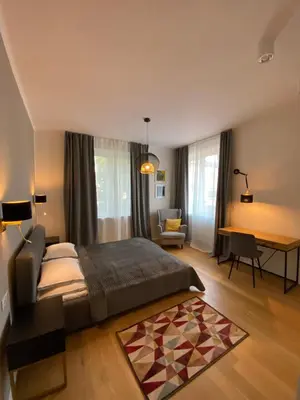 a bedroom with a bed and a desk in a room at Comfort Garden View Apartment in Kraków