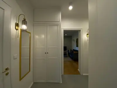 a hallway with a mirror and a white door at Comfort Garden View Apartment in Kraków