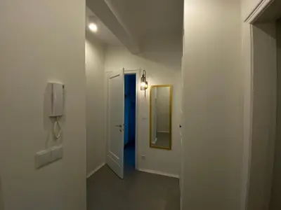 a hallway with a blue door and a mirror at Comfort Garden View Apartment in Kraków