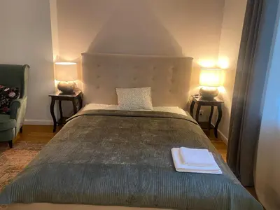 a bedroom with a large bed with two lamps at Comfort Garden View Apartment in Kraków