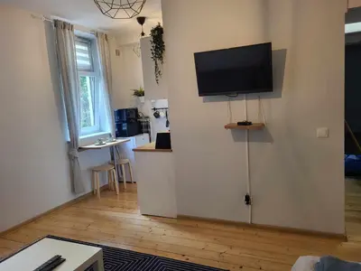 a living room with a flat screen tv on a wall at ViP Apartment Krakow in Kraków