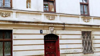a building with a red door and an arch way at ViP Apartment Krakow in Kraków