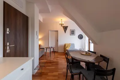 a kitchen and dining room with a table and chairs at Zakątek Apartments in Kraków