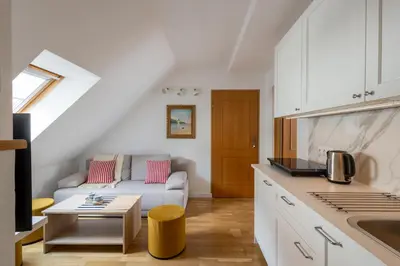 a kitchen and a living room with a couch at Zakątek Apartments in Kraków
