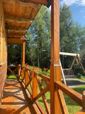 a wooden porch with a wooden fence and flowers at Domek w górach in Nowy Targ
