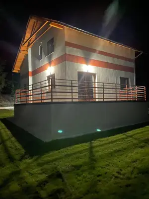a house with a flag on the side of it at Domek w Koszarawie Bystrej in Koszarawa