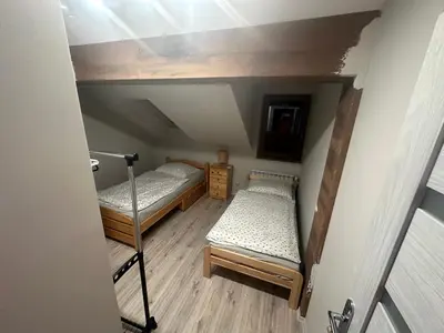 an attic room with two bunk beds and a ladder at Domek w Koszarawie Bystrej in Koszarawa