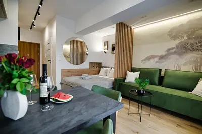 a hotel room with a bed and a green couch at Good rest in 52 in Zator